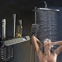 Vrouw onder een werkende chromen regendouche. Douchepaneel met digitale temperatuurweergave.