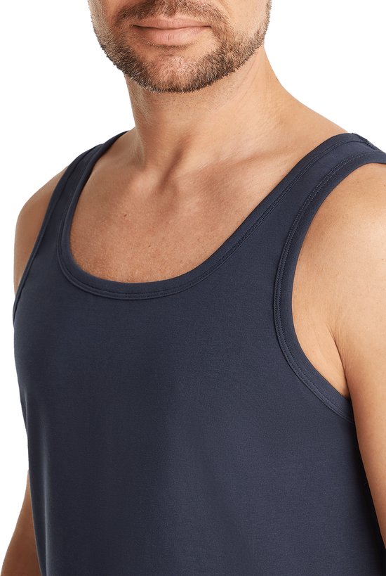 Close-up van een man die een donkerblauwe singlet draagt.