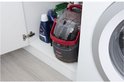 Een BISSELL SpotClean Pro op een witte plank, naast schoonmaakmiddelen.