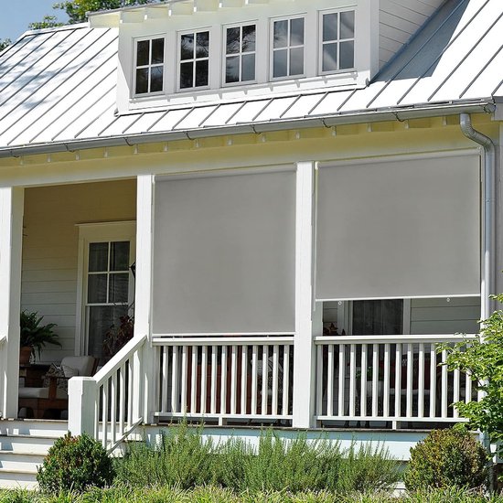 Stores gris pour un porche avec balustrade blanche et maison de campagne.