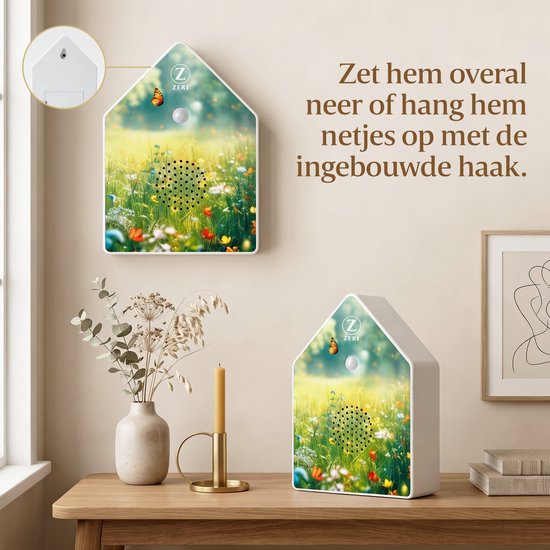 Zeri geluidshuisje met bloemenveld print hangt aan de muur naast een plant en kaars.