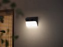 Eufy solar wandlamp camera verlicht 's nachts een muur.