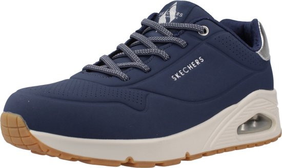 Driekwart aanzicht van donkerblauwe Skechers sneaker met zilveren accenten, vetersluiting en beige dempingszool.