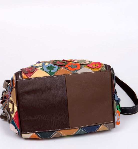 Onderkant van bruine lederen schoudertas met patchwork van ruiten en bloemen.