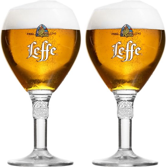 Deux verres à bière Leffe remplis de bière dorée et de mousse, avec une tige ouvragée et gravée.