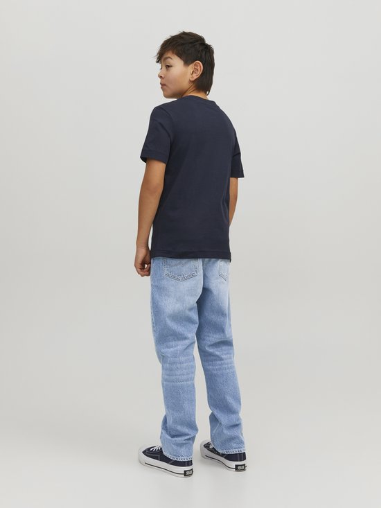 Jongen van achteren gezien, in een lichtblauwe, wijde spijkerbroek en donker T-shirt.