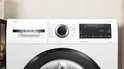 Wit Bosch Serie 6 wasmachine met wit en grijs bedieningspaneel en draaiknop.