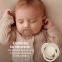 Slapende baby met Difrax Lovi fopspeen 18+ maanden, crème. Het schildje heeft ventilatie-uitsparingen.
