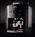 Zwarte Krups volautomaat espressomachine, close-up van espresso in glas.