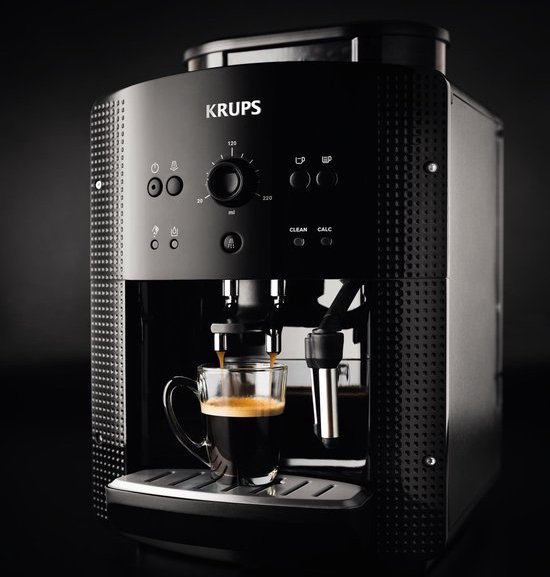 Zwarte Krups volautomaat espressomachine, close-up van espresso in glas.