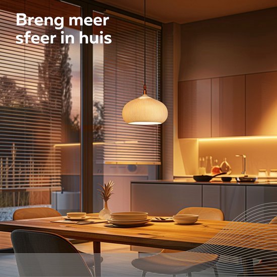 Eettafel en keuken verlicht door een decoratieve hanglamp met geribbelde kap en warme sfeerverlichting.