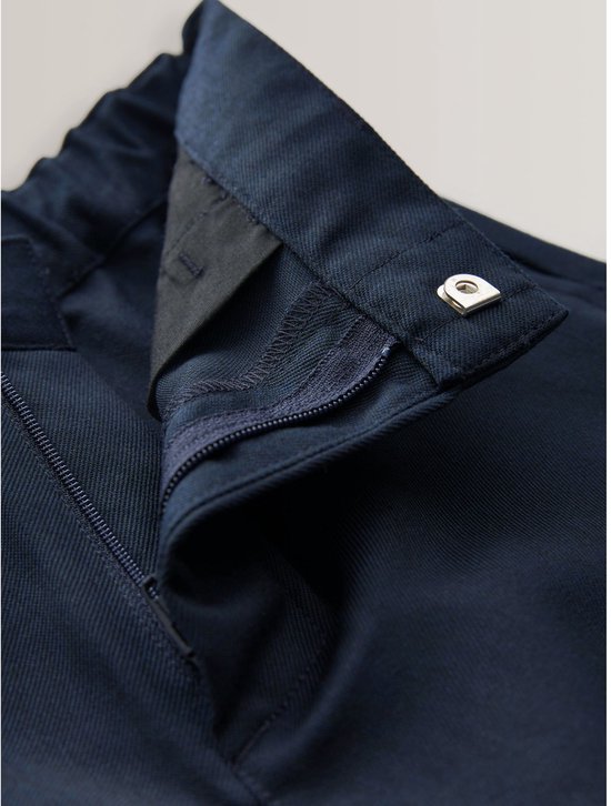Donkerblauwe broek met ritssluiting, knoopsluiting en een drukknoop.