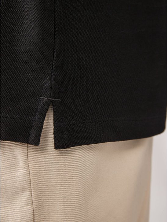 Onderkant van een zwart poloshirt met lange mouwen, met splitjes aan de zijkanten.