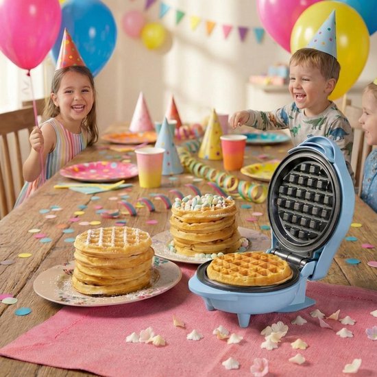 Blauw wafelijzer op tafel vol slingers en confetti. Kinderen vieren feest met wafels.
