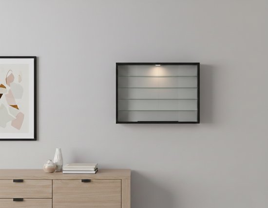 Kleine zwarte vitrinekast met glazen planken en verlichting, hangend aan een grijze muur.