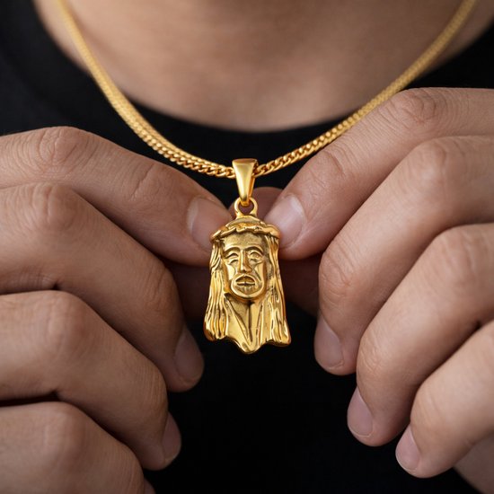 Gouden hanger met gezicht van Jezus, gedragen door een persoon met een zwart shirt.
