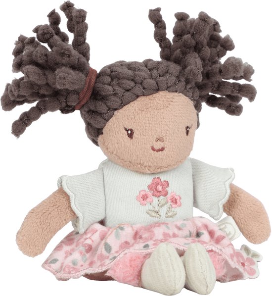Poupée en peluche assise aux cheveux bruns bouclés, haut vert menthe à fleurs et jupe rose à fleurs.