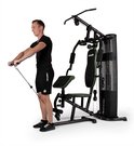 Man doet biceps curl aan zwart krachtstation met groene accenten.