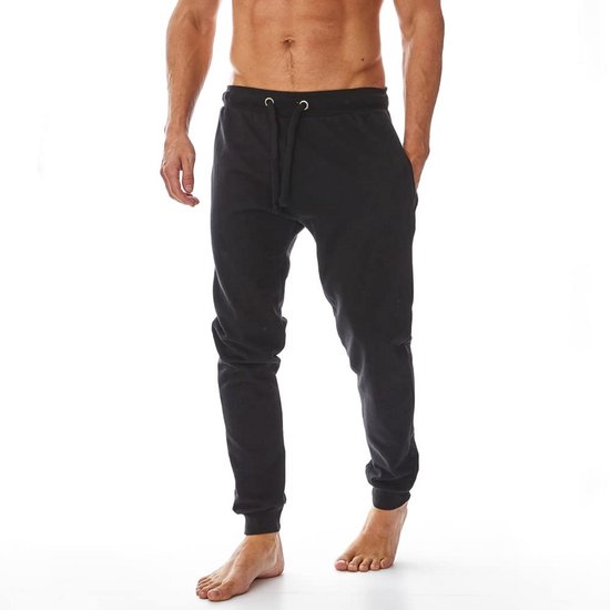 Zwarte joggingbroek met trekkoord, getoond door een man zonder shirt met handen in de zakken.