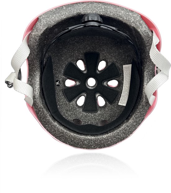 Binnenkant van een roze kinderhelm met ventilatiegaten en verstelknop.