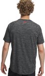 Man draagt een zwart gestreept sportshirt met rood Under Armour logo op de achterkant.