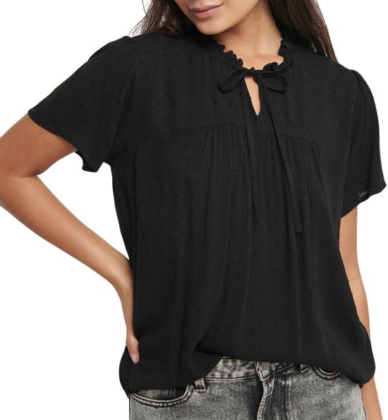 Zwarte blouse met korte mouwen, ruchekraag en strikdetail bij de hals. De stof heeft een subtiel stipjespatroon.