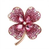 Roze klaverbroche bezet met glinsterende steentjes en grotere roze druppelvormige kristallen in het midden. Gouden rand en steel.