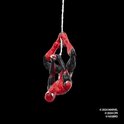 Spiderman actiefiguur in rood met zwarte details, hangend aan een web.