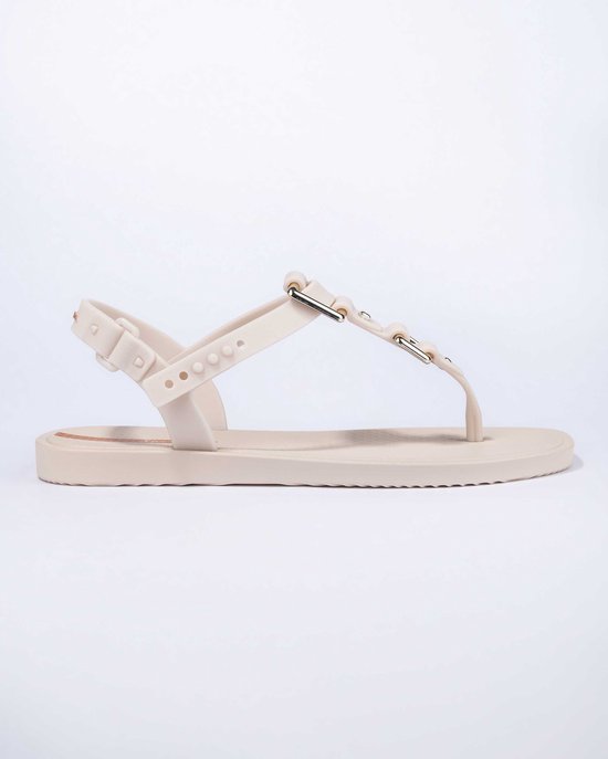 Lichtbeige Ipanema slipper met een enkelbandje en een band over de wreef met gouden gespen.