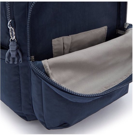 Vue latérale d'un sac à dos Kipling bleu foncé, avec une poche latérale ouverte et un porte-clés singe gris.