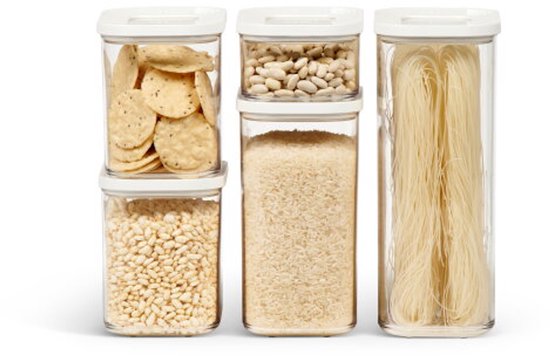 Cinq boîtes de conservation Mepal Modula empilées sur un fond blanc, remplies de crackers, de riz, de haricots blancs et de vermicelles.