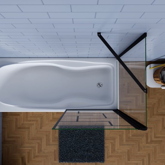 Vue de dessus d'une baignoire avec paroi de bain noire, motif vitrail, parquet et tapis anthracite.