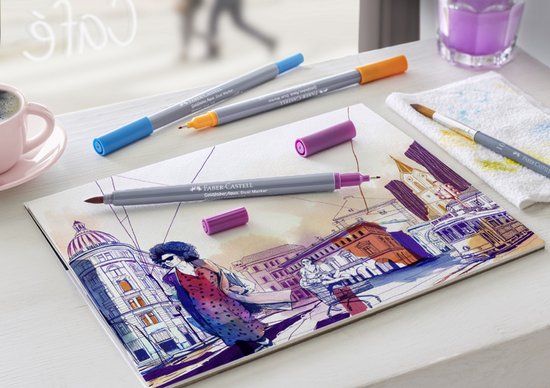 Quatre stylos Faber-Castell sur un carnet de croquis avec un dessin aquarelle d'une scène de ville.