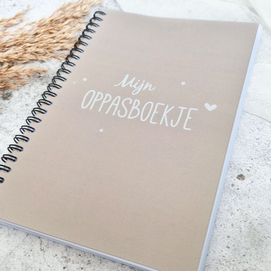 Lichtbruin invulboek met de tekst "Mijn Oppasboekje" in witte letters, met kleine sterretjes en hartjes.