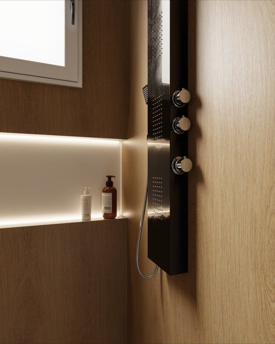 Un panneau de douche noir avec des boutons chromés à côté d'un mur en bois et d'une niche éclairée avec des distributeurs de savon.