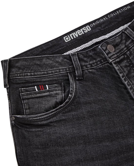 Detail van een zwarte jeans met klein zakje en rood-wit-blauwe bies, met Riverso Original Collection op de band.