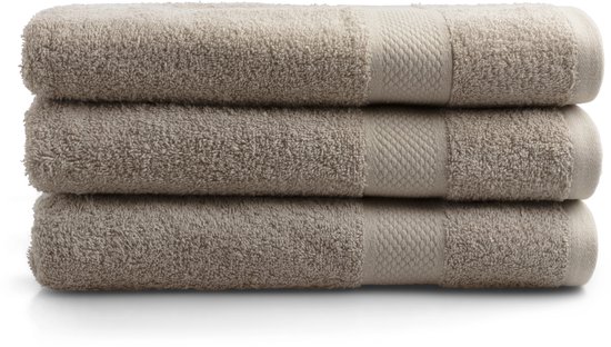 Stapel van drie beige badhanddoeken met een ribbelrand.