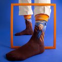 Donkerbruine sokken met "De Schreeuw" van Munch erop, bovenkant oranje en blauw gestreept.
