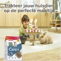 Meisje en twee konijnen met een zak Care+ Junior konijnenvoer en een kartonnen huisje. "Trakteer jouw huisdier op de perfecte maaltijd."