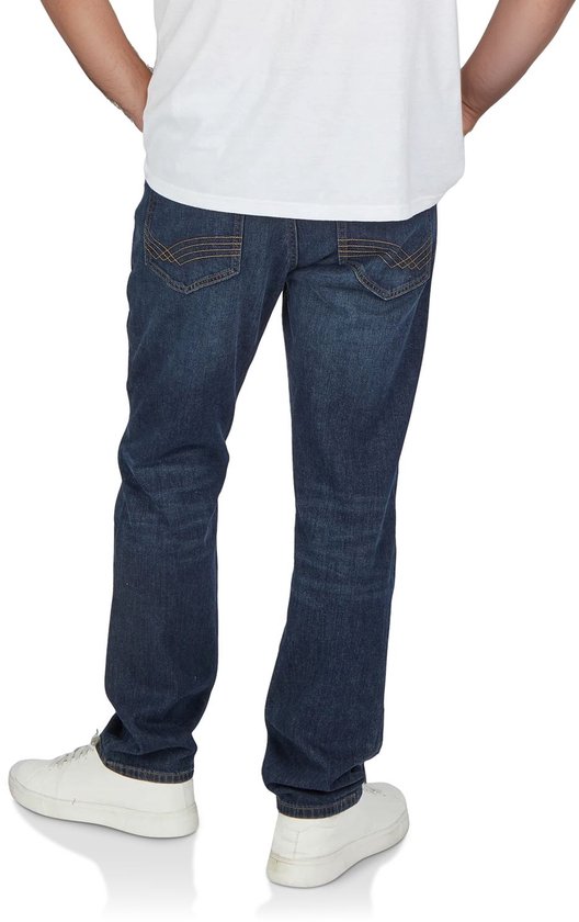 Achterkant van een man die een blauwe jeans broek draagt met een wit T-shirt en witte sneakers.