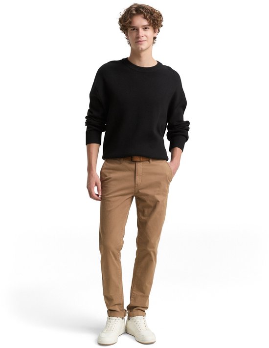 Man met bruine chino broek en zwart gebreid vest.