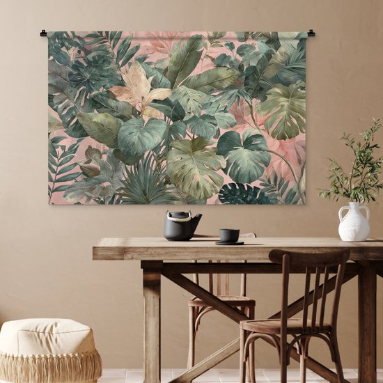 Een wandkleed met een tropische bladerenprint in groen en roze, hangend boven een houten eettafel met stoelen.