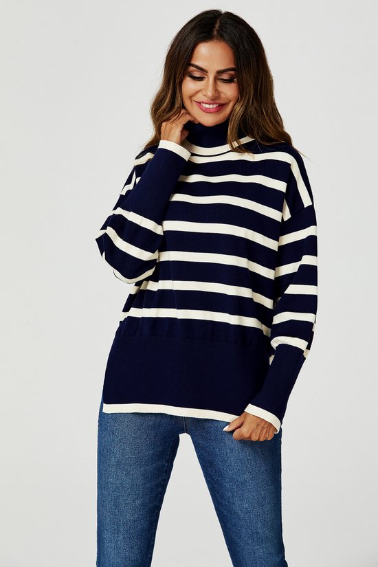 Lachende vrouw met donkerblauwe gestreepte coltrui, jeans, met haar hand aan haar nek.