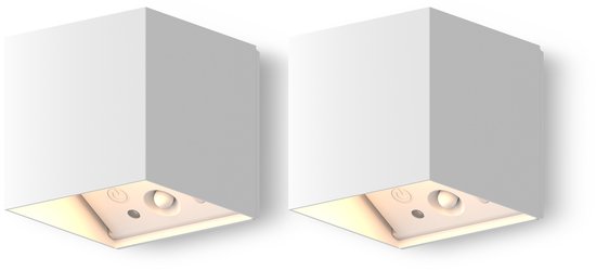 Twee witte kubusvormige wandlampen met indirect licht, geïsoleerd op een zwarte achtergrond.