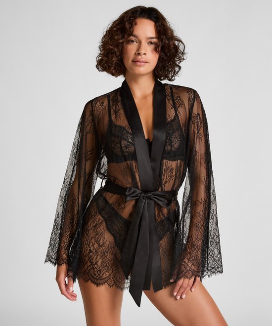 Zwarte kanten kimono met satijnen ceintuur en wijde mouwen, gedragen door model.