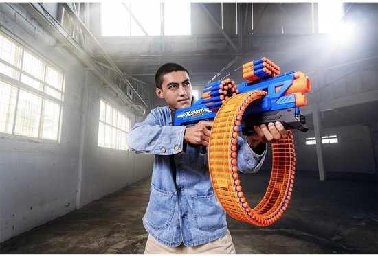 Man in spijkerjack met blauwe en oranje speelgoedblaster met rond magazijn.