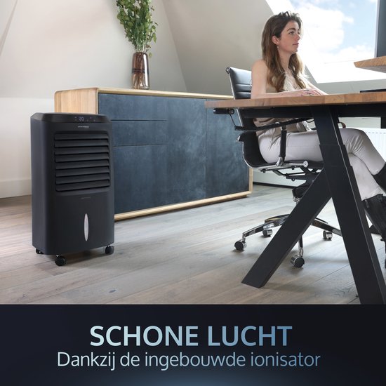 Zwarte mobiele aircooler op de achtergrond terwijl een vrouw aan een bureau zit, schone lucht dankzij de ionisator.