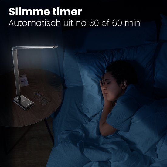 Vrouw slaapt naast een zwarte Auronic bureaulamp met draadloze oplader, die aanstaat. Slimme timer.