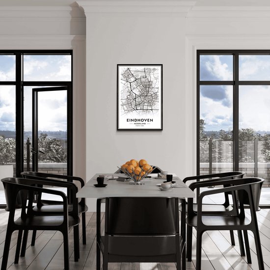 Affiche de carte de ville d'Eindhoven, Pays-Bas, en noir et blanc, encadré dans un cadre noir, au-dessus d'une table à manger avec des chaises.
