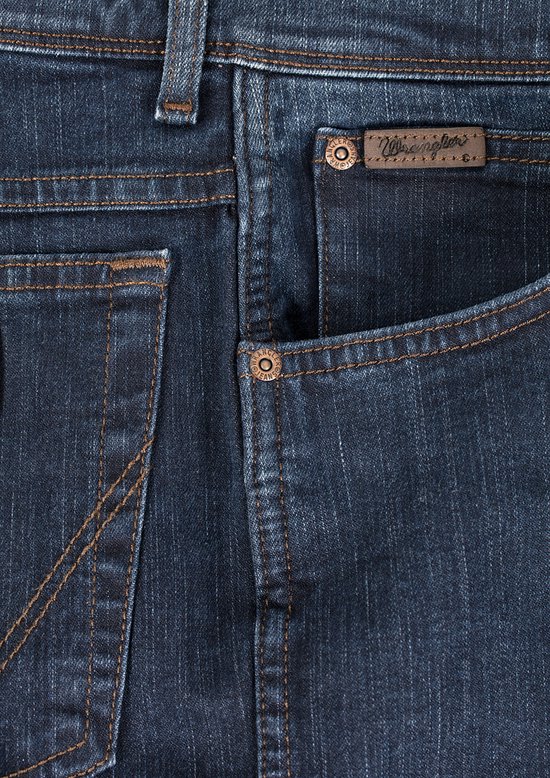 Close-up van de zak van een donkerblauwe Wrangler jeans met koperen knopen en bruin merklabel.